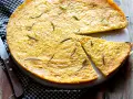 Farinata di ceci dorata e profumata al rosmarino, appena sfornata e tagliata a spicchi, pronta per essere gustata.