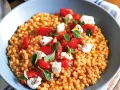 Fregola con pomodorini freschi, mozzarella e basilico. Un piatto colorato e gustoso, perfetto per le tue fregola ricette semplici.
