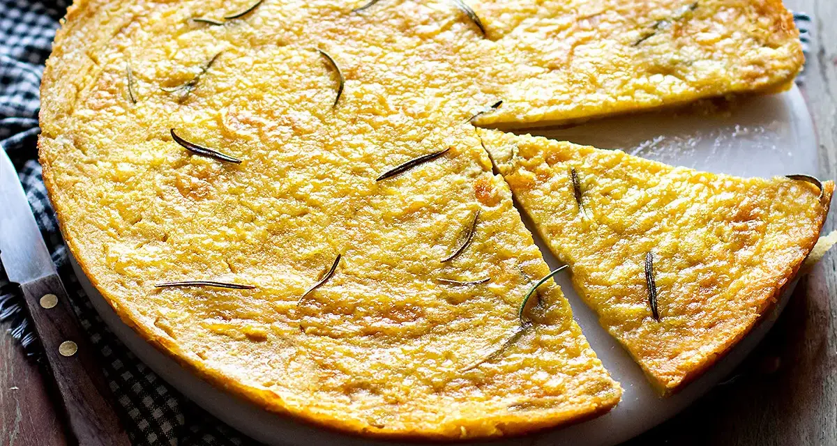 Farinata di ceci dorata e profumata al rosmarino, appena sfornata e tagliata a spicchi, pronta per essere gustata.