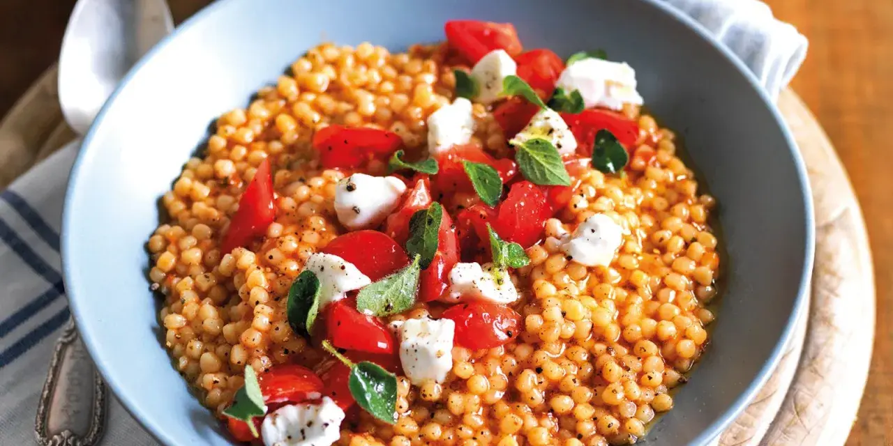 Fregola con pomodorini freschi, mozzarella e basilico. Un piatto colorato e gustoso, perfetto per le tue fregola ricette semplici.