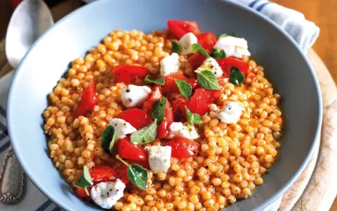 Fregola con pomodorini freschi, mozzarella e basilico. Un piatto colorato e gustoso, perfetto per le tue fregola ricette semplici.