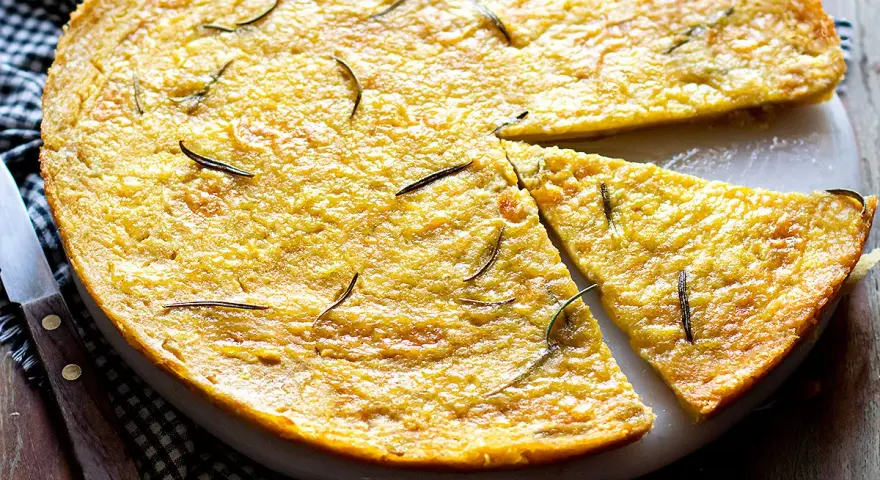 Farinata di ceci dorata e profumata al rosmarino, appena sfornata e tagliata a spicchi, pronta per essere gustata.