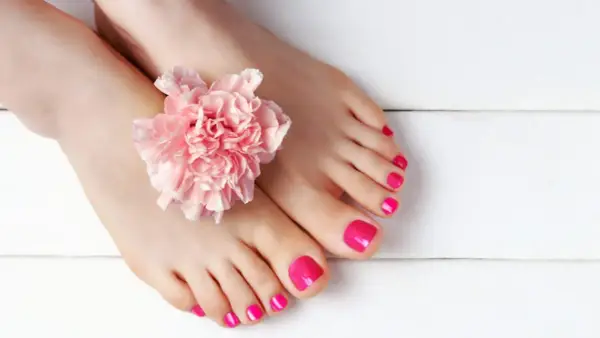 Unghie piedi gel estate, rosa acceso, con un fiore delicato. Perfette per la bella stagione.